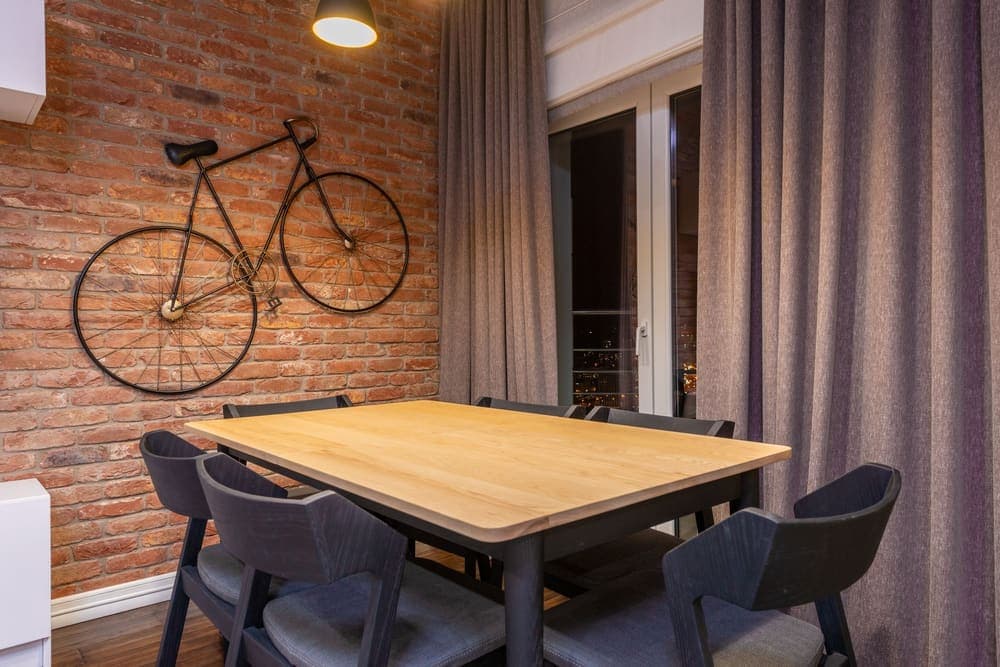 A bicycle stored upright against the wall of an apartment room