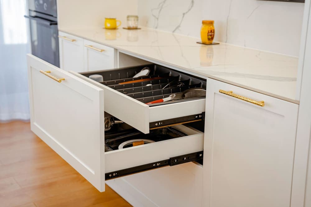 An open kitchen drawer fitted with a compartmented utensil insert