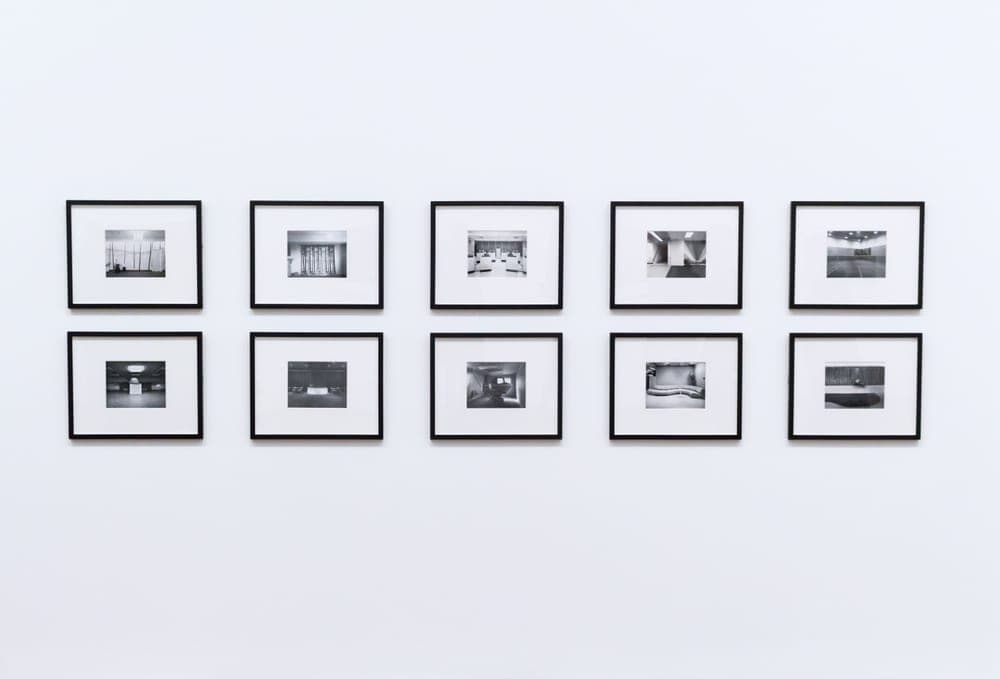 Framed pictures arranged on a plain white wall