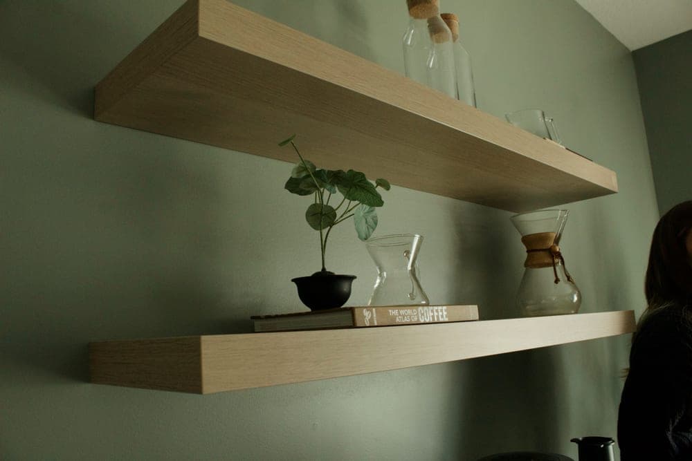 A wall shelf holding a plant in a small room