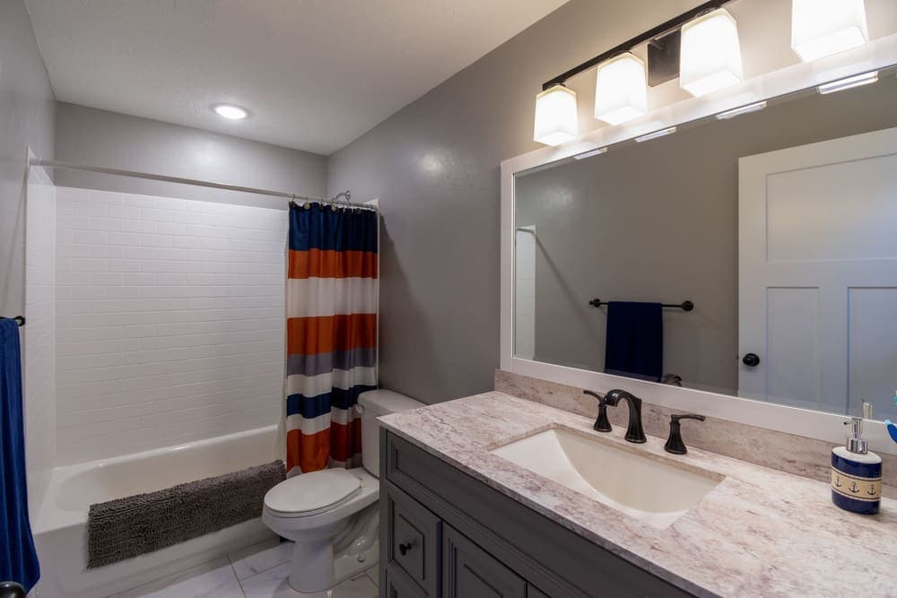 A shower curtain hanging across a tiled bathtub alcove
