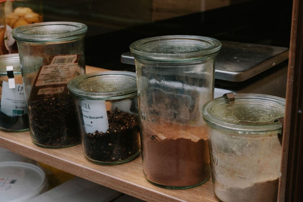 Glass spice jars arranged on a kitchen shelf