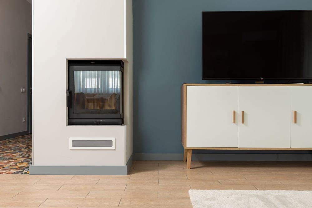 A flat-screen television standing on a low sideboard rather than mounted on the wall behind it