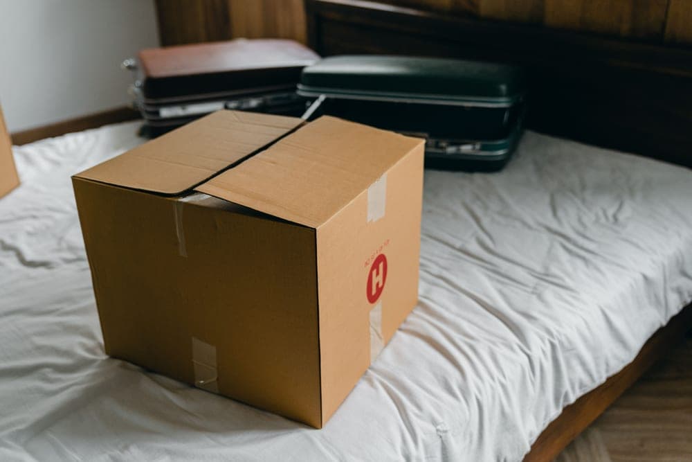 Storage boxes and cases on the floor beside a bed in a bedroom