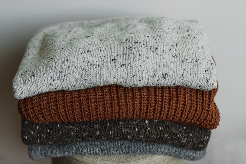 A stack of folded knit sweaters