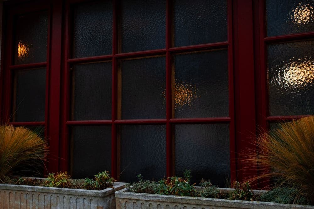 A frosted glass window lit from inside at night, seen from the street