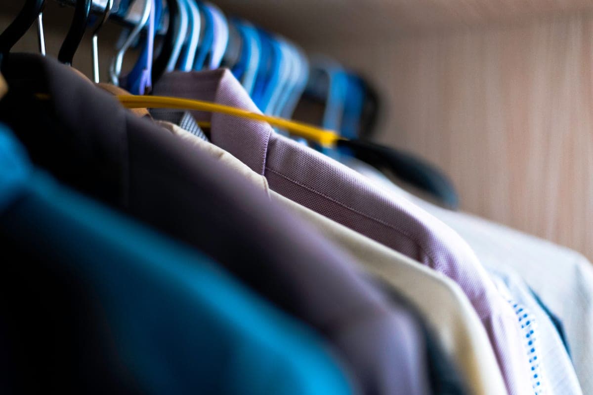 Clothes hanging in an organized apartment closet