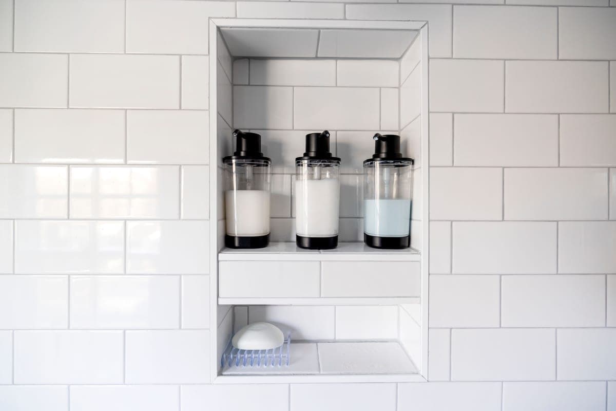 A small bathroom shelf holding bottles